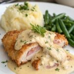 This Creamy Chicken Cordon Bleu recipe features crispy breaded chicken stuffed with ham and Swiss cheese, smothered in a rich, creamy sauce. Perfect for dinners or special occasions! Save this mouthwatering recipe and make it tonight!