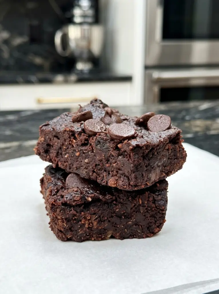 Stacked slices of Flourless Black Bean Brownie topped with melted chocolate chips