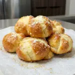 3-Ingredient Cottage Cheese Garlic Knots 9 3-Ingredient Cottage Cheese Garlic Knots stacked on parchment, golden and topped with grated parmesan