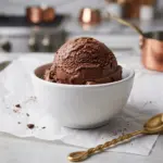 Scoop of Chocolate Cottage Cheese Ice Cream in a white bowl with a gold spoon