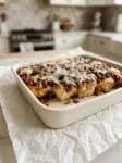 Pan of gluten-free cranberry pecan breakfast rolls topped with pecans and white chocolate glaze