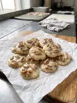 Vanilla pecan pralines, creamy white chocolate pralines topped with pecans and walnuts, on parchment paper